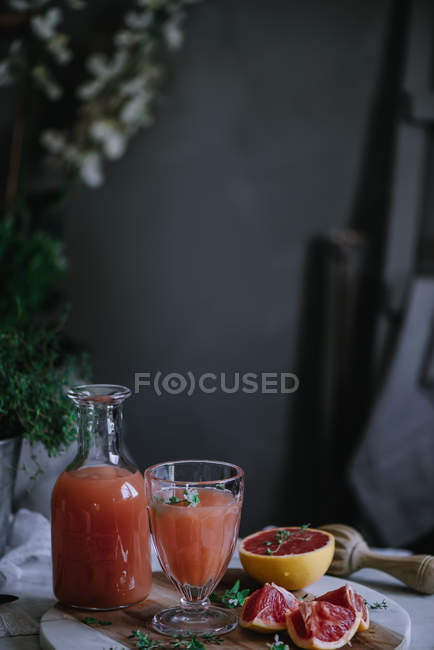 Succo di pompelmo fresco in vetro e bottiglia con ingrediente sul tavolo della cucina — Foto stock