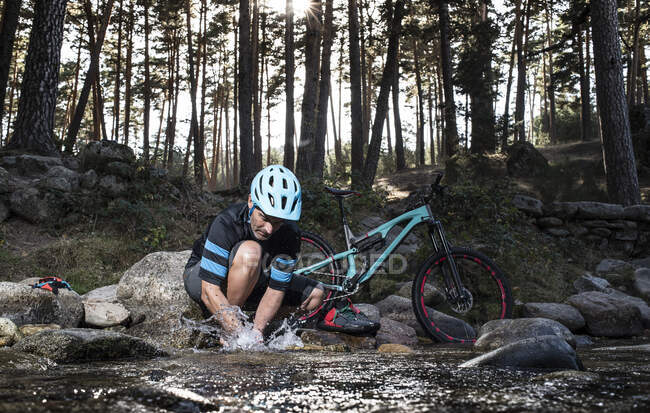 Motociclista fazendo uma pausa na montanha- refrescante no rio — Fotografia de Stock
