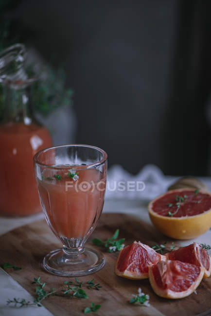 Succo di pompelmo fresco in vetro con ingrediente sul tavolo della cucina — Foto stock