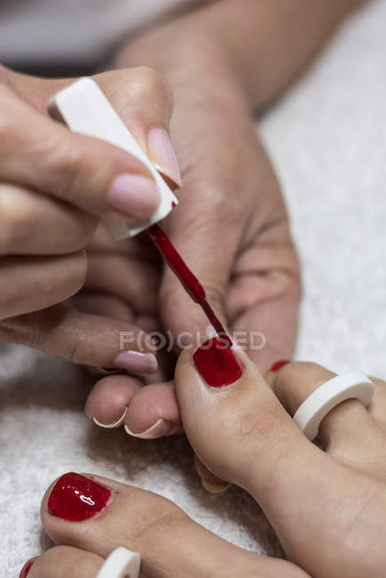 Mujer manicura pintura pies uñas de cliente en salón de belleza - foto de stock