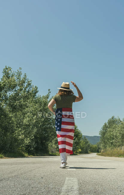 Mujer caminando con bandera americana - foto de stock