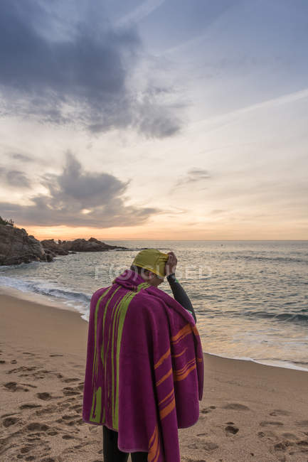 Триатлоніст стоїть на піщаному пляжі — стокове фото