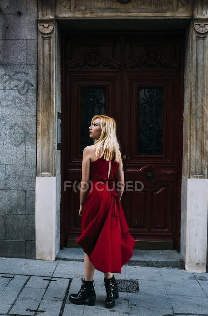 Jovem mulher atraente em pé na frente do portão velho — Fotografia de Stock
