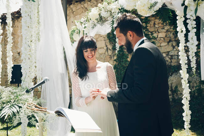 Молодые жених и невеста обмениваются обручальными кольцами — стоковое фото