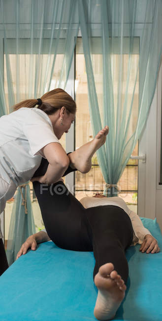 Therapist doing body treatment for stimulating body issues in massage room — Stock Photo