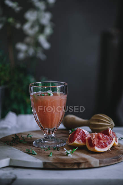 Suco de toranja fresco em vidro em placa de madeira com ingrediente — Fotografia de Stock