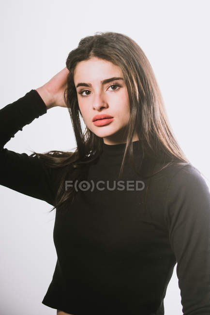 Дівчина в чорній черепасі светр позує на сірому фоні — стокове фото