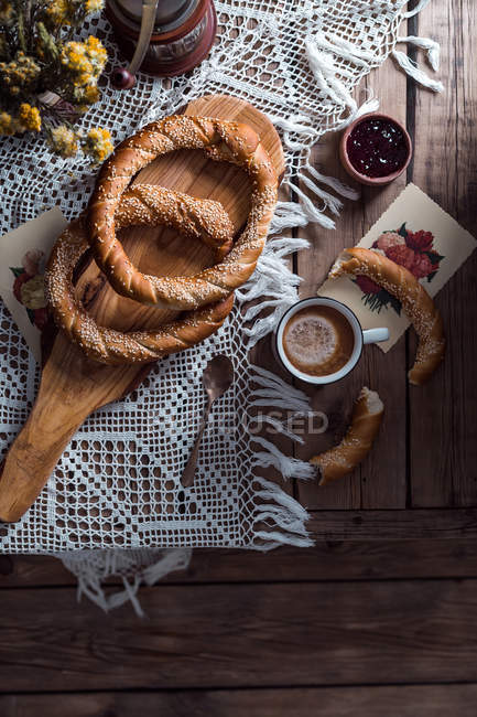 Top view of tasty circle-shaped pastries and cup of cocoa on openwork fabric on table. — Stock Photo