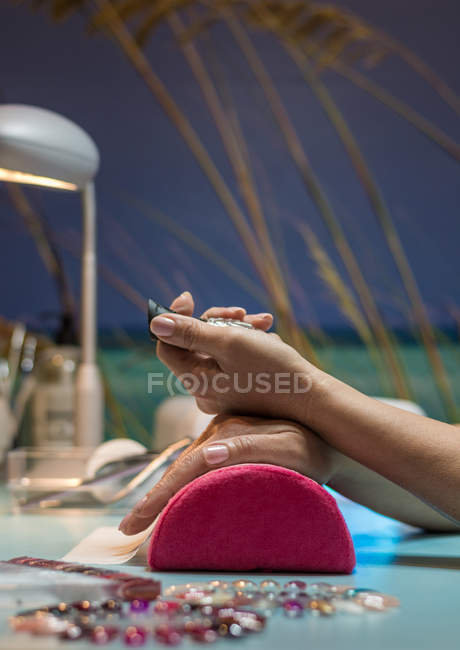 Жінка тримає пляшку лаку для нігтів в салоні краси — стокове фото