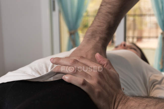 Терапевт проводит альтернативную терапию тела для стимуляции тканей тела в массажном кабинете — стоковое фото