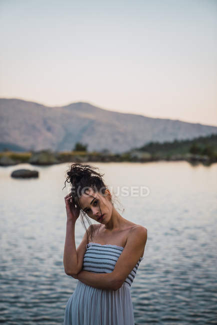 Jeune femme debout seule sur la rive du lac — Photo de stock