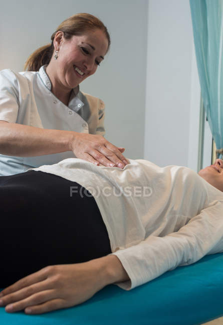 Therapist doing body treatment for stimulating body issues in massage room — Stock Photo