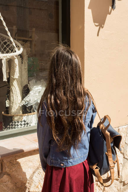 Девушка с рюкзаком стоит и смотрит на дело — стоковое фото