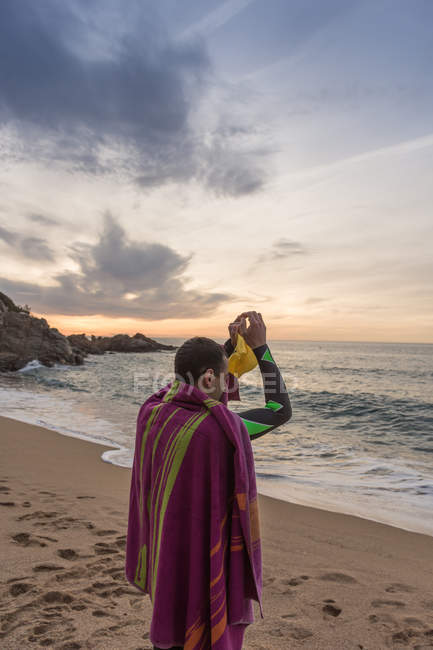 Триатлон, стоящий на песчаном пляже — стоковое фото
