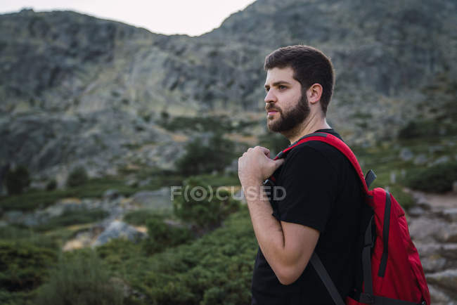 Homem barbudo caminhadas com mochila na natureza das montanhas — Fotografia de Stock