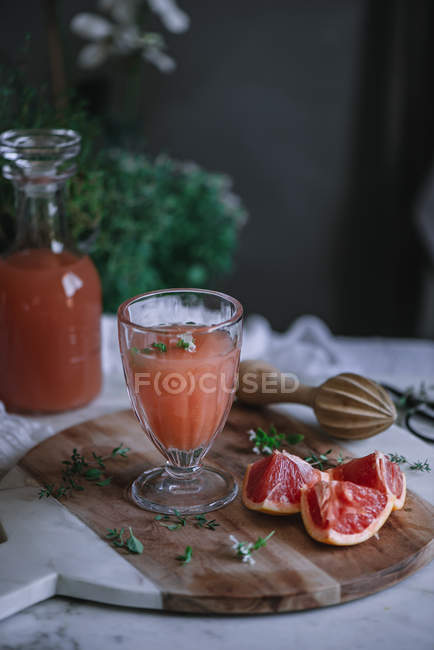 Frischer Grapefruitsaft im Glas auf Holzplatte mit Zutat — Stockfoto