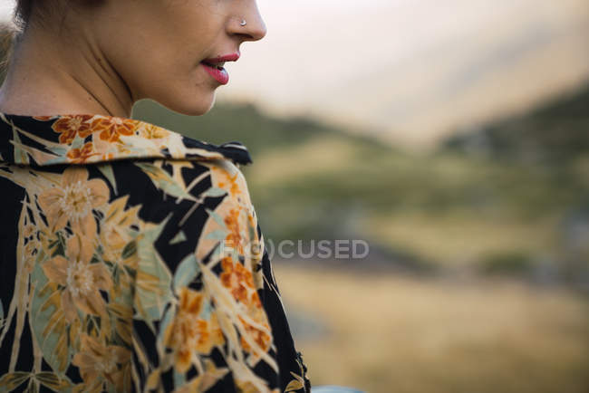 Cropped de femme avec nez percing portant chemise colorée comme debout à l'extérieur — Photo de stock