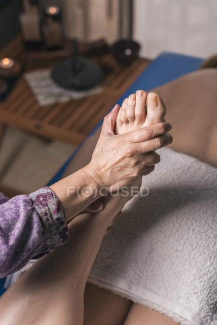 Terapista che fa massaggio riflessologico ai piedi su paziente donna — Foto stock