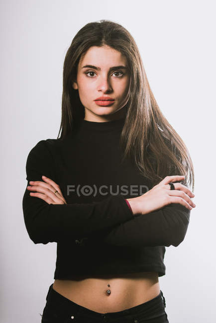 Sexy girl in black outfit with belly piercing posing on grey background — Stock Photo