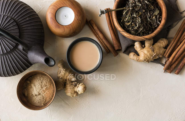 Tazza di tè orientale Chai con latte, cannella, zenzero, pepe bianco e cardamomo sulla superficie beige — Foto stock