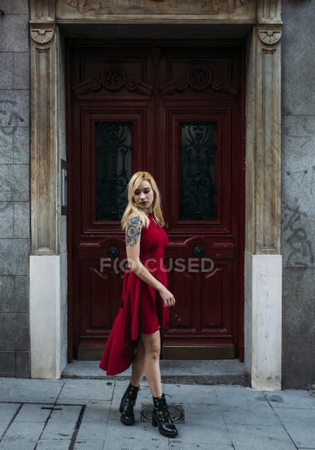 Молодая привлекательная женщина стоит перед старыми воротами — стоковое фото