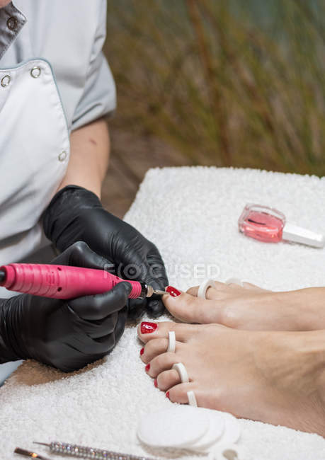 Female manicurist doing pedicure to client in beauty salon — Stock Photo