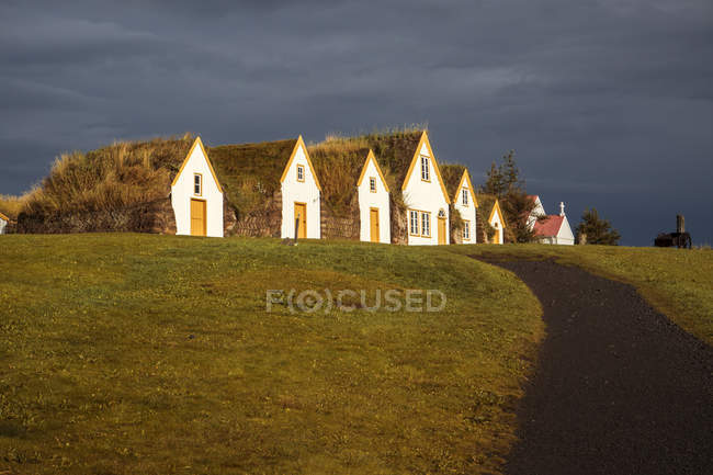 Fila di villette con tetto di paglia sul campo, Islanda — Foto stock
