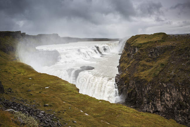 Водопад каскад и каменные скалы, Исландия — стоковое фото