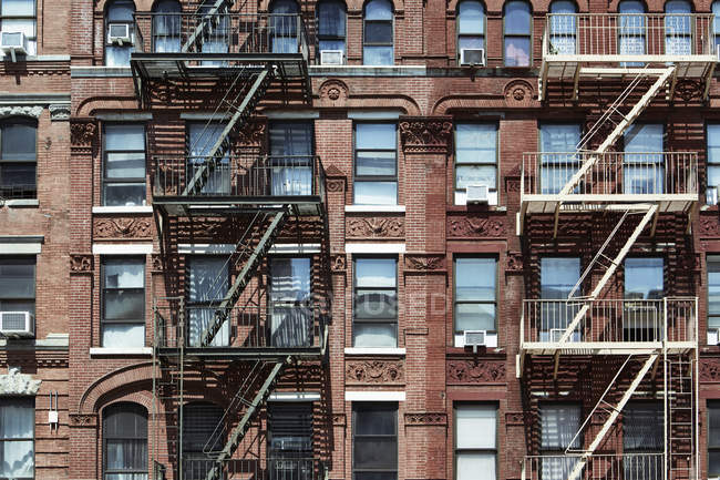 Metal staircases on facade of brick apartment building on street, New York, USA — Stock Photo