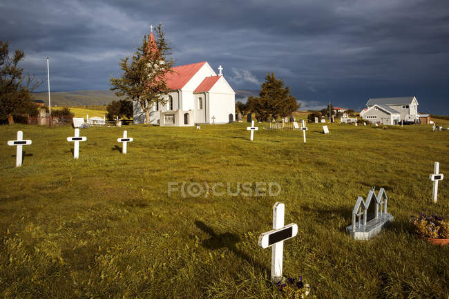 Кладбище рядом с католическим храмом в деревне, Исландия — стоковое фото