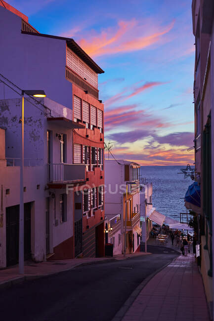 Vista a la pequeña calle en la colina que conduce al océano en las luces del atardecer en The Palm, España. - foto de stock
