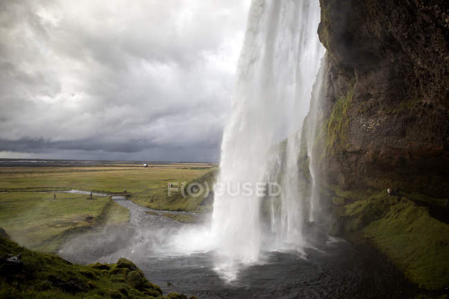 Cachoeira salpicando de penhasco de pedra, Islândia — Fotografia de Stock