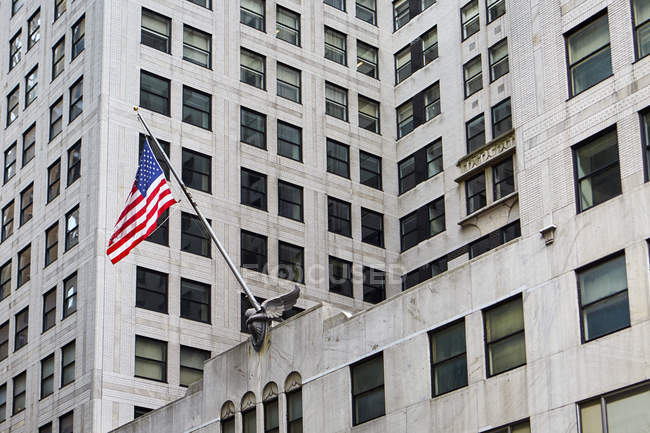 Bandiera di Stati Uniti d'America appesa su facciata di edificio moderno su strada di Nuova York, Stati Uniti — Foto stock