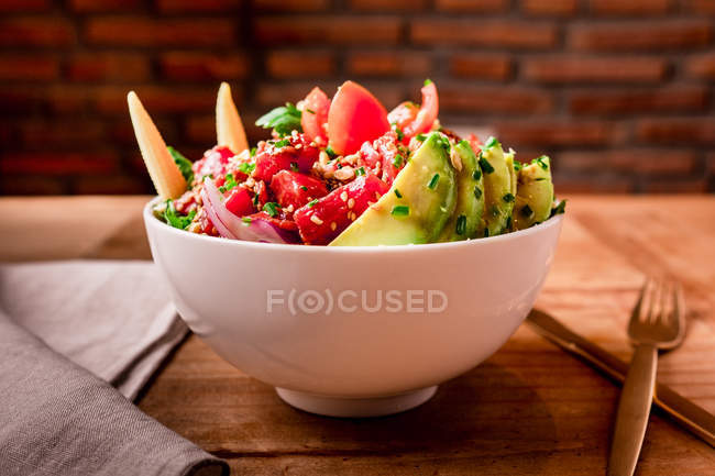 Миска смачного овочевого салату з авокадо на дерев'яному столі — стокове фото