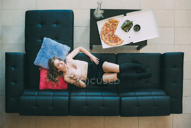 Mulher deitada no sofá com maconha — Fotografia de Stock