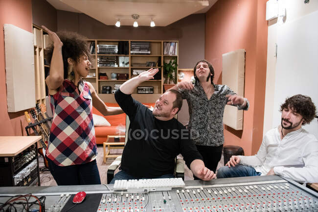 Group of people rejoicing over success and having fun?after recording music in studio — Stock Photo