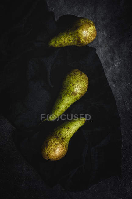 Peras verdes frescas en la superficie negra - foto de stock