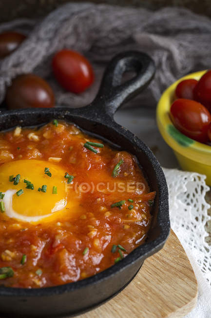 Fried egg with tomato and red peppers in frying pan — Stock Photo
