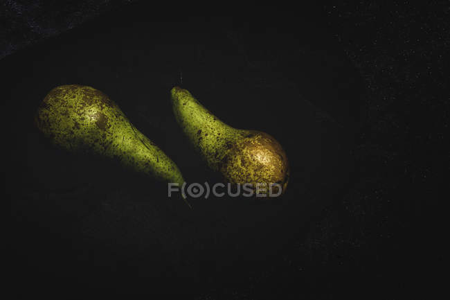 Frische grüne Birnen auf schwarzem Hintergrund — Stockfoto