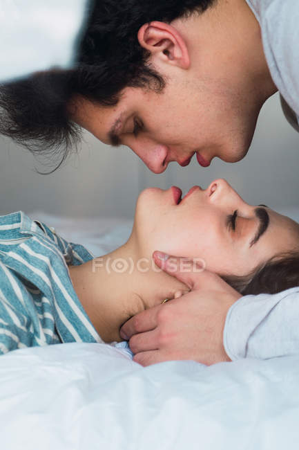 Ніжна пара лежить на ліжку обличчям до обличчя — стокове фото