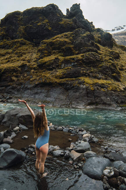 Young woman standing in mountain river — Stock Photo