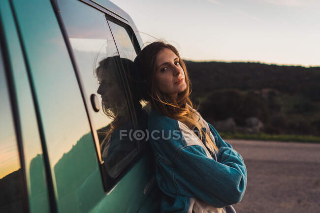 Гарненька жінка спирається на машину — стокове фото