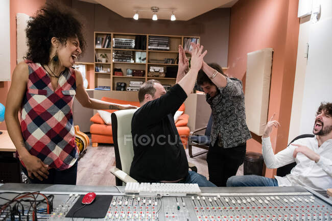 Group of people rejoicing over success and having fun?after recording music in studio — Stock Photo