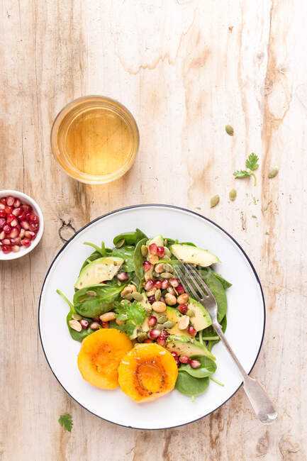 Top view of a Spinach, pomegranate and peach salad — Stock Photo