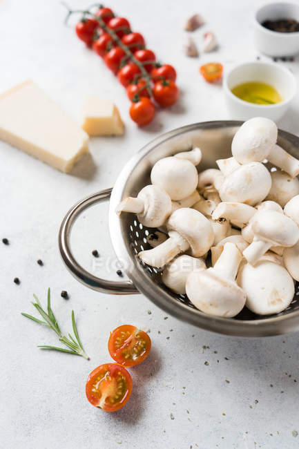 White mushrooms and ingredients for cooking on table — Stock Photo