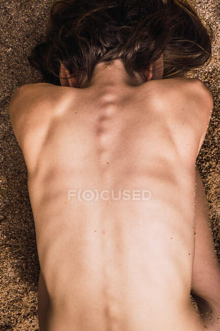 From above young nude unrecognizable woman lying on sand. — Stock Photo