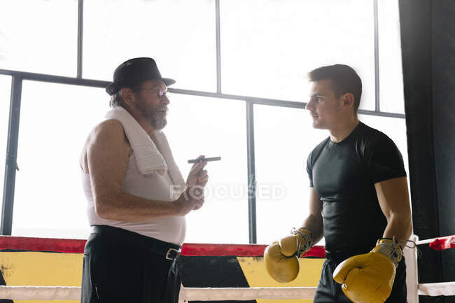 Бічний вид дорослого чоловіка з сигарним боксером у спортзалі.. — стокове фото