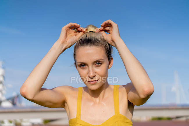 Junge blonde Frau berührt Haare im Freien — Stockfoto