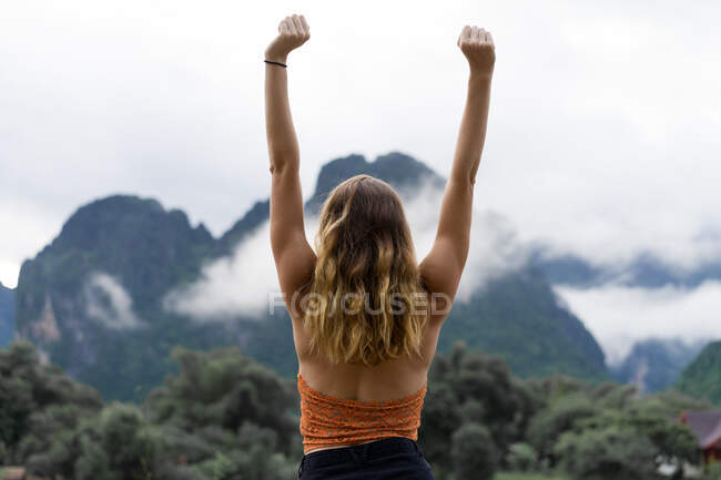 Donna con le mani in alto in montagna — Foto stock