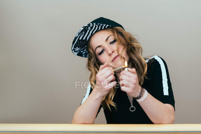 Mujer joven encendiendo un porro de cannabis - foto de stock